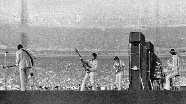 Des musiciens sur scène dans un stade. 