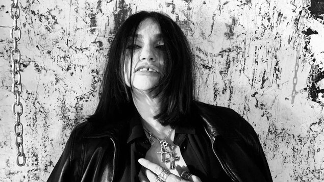 Photo en noir et blanc de Béatrice Dalle, qui porte plusieurs croix autour du cou