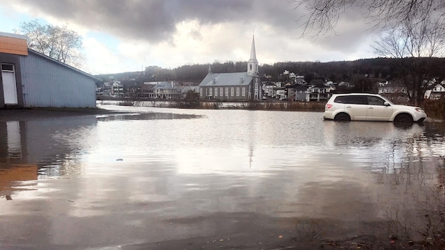 Photo d'inondation où l'on voit un véhicule submergé jusqu'aux portières.
