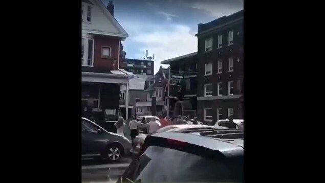 Un bébé sur un toit et des gens qui le regardent de la rue. Un bébé sur un toit et des gens qui le regardent de la rue.