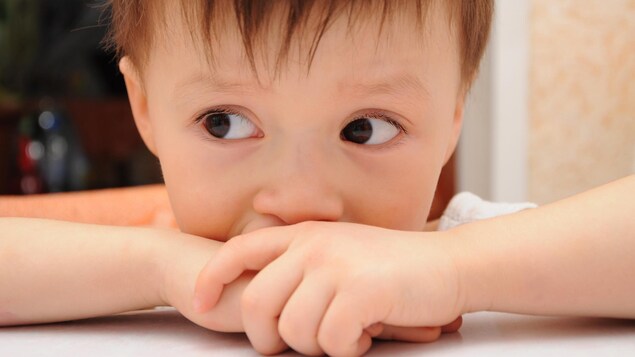 Un enfant regarde nerveusement vers la gauche.