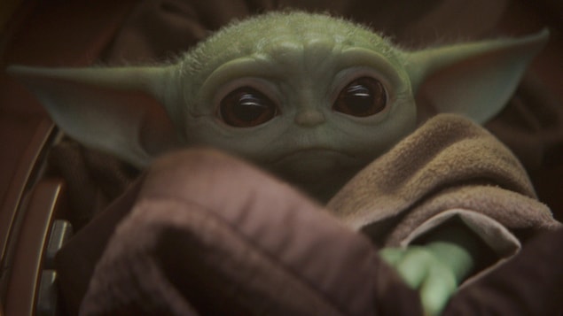 Gros plan sur Bébé Yoda et ses yeux globuleux.