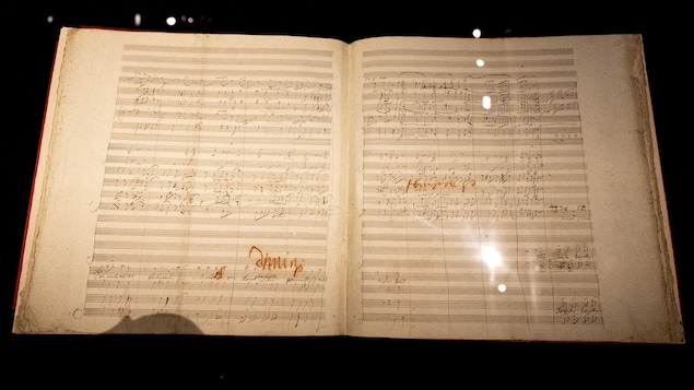 Un vieux livre ouvert sur les partitions de la symphonie de Beethoven.