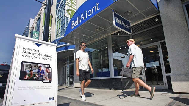 Des passants devant un magasin Bell Aliant au centre-ville d'Halifax. Des passants devant un magasin Bell Aliant au centre-ville d'Halifax.
