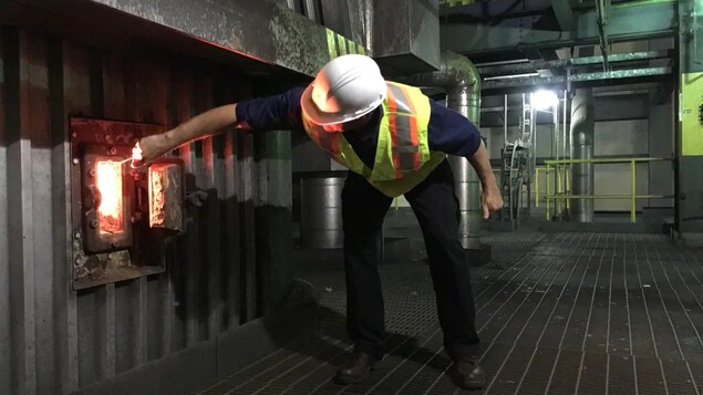 Un ouvrier examine une chaudière dans la centrale.