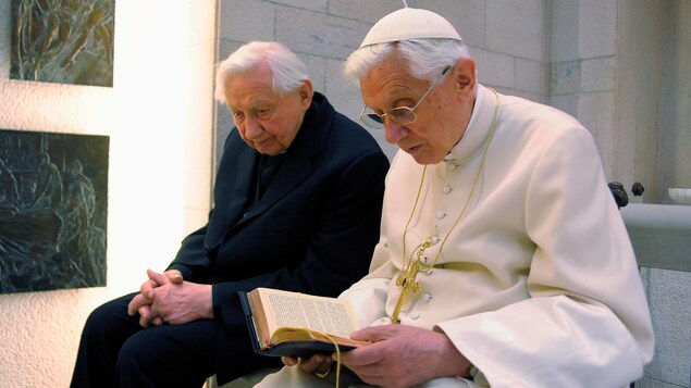 Le pape Benoît XVI (à droite), qui a quitté ses fonctions en février 2013, prie avec son frère Mgr Georg Ratzinger dans sa chapelle privée au Vatican, le 14 avril 2012.