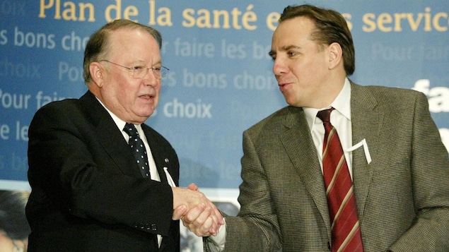 Le deux hommes se serrent la main tout en souriant.