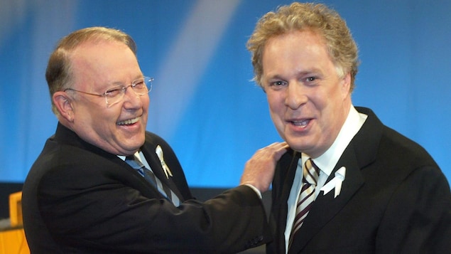 Les deux hommes rient de bon coeur.