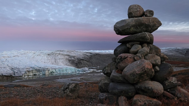Un monticule de pierres se dresse près d’un glacier au Groenland