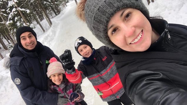 Une selfie d'une famille de 4, en hiver, dans une forêt