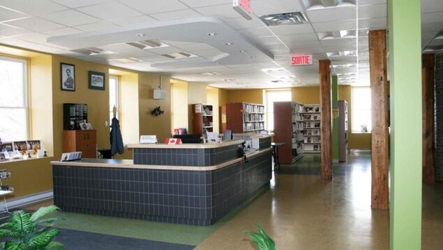 Le comptoir au centre de la salle est revêtu de tuiles noires et entouré de casiers de livres. Le comptoir au centre de la salle est revêtu de tuiles noires et entouré de casiers de livres.