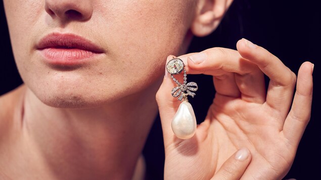 Un pendentif orné de diamants et d'une perle. Un pendentif orné de diamants et d'une perle.