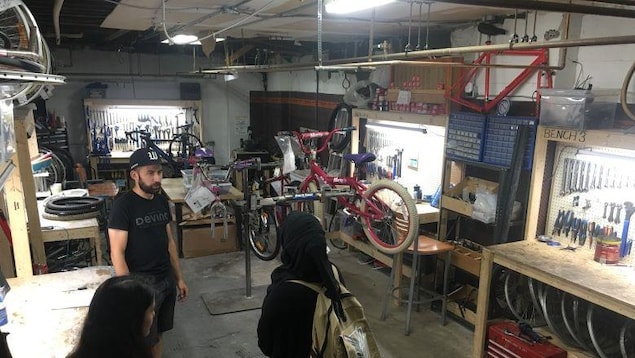 Deux personnes parlent à un employé de Bike Windsor Essex. Deux personnes parlent à un employé de Bike Windsor Essex.