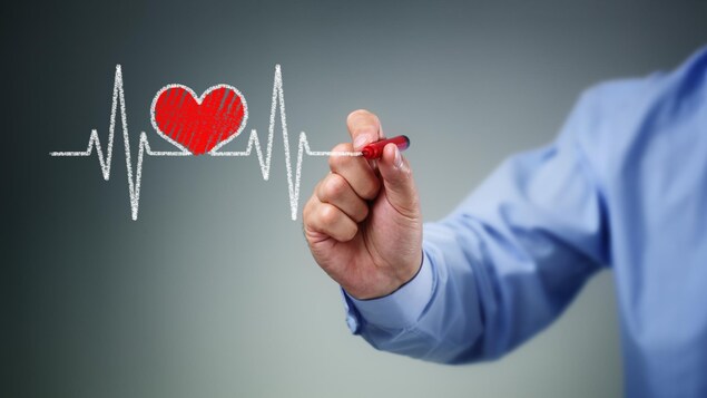Une main qui dessine un graphique cardiaque. Une main qui dessine un graphique cardiaque.