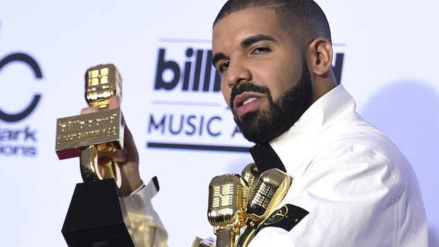 Drake tient 4 de ses 13 trophées dans les bras.