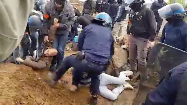 Des policiers utilisent la force pour arrêter des manifestants.