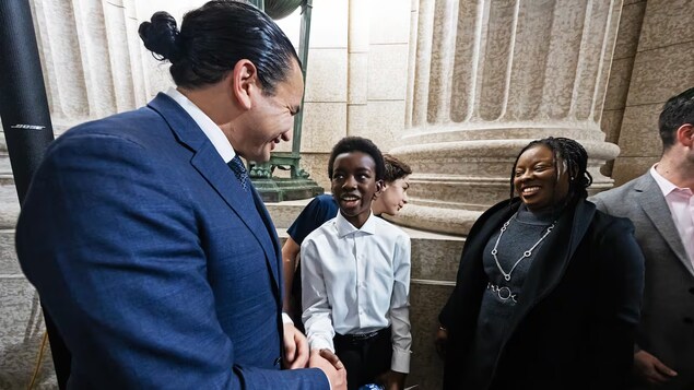 أولوفيسايو باكيني، 13 عاماً، يصافح رئيس حكومة مانيتوبا، واب كينو، خلال حدث بمناسبة شهر تاريخ السود في مقر الجمعية التشريعية للمقاطعة في وينيبيغ في 16 شباط (فبراير) 2024.
