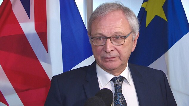 Blaine Higgs devant des drapeaux.