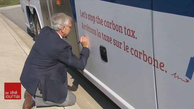 Blaine Higgs, équipé d'un crayon, signe son nom sur l'autobus de campagne. Blaine Higgs, équipé d'un crayon, signe son nom sur l'autobus de campagne.