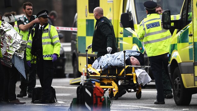 Une personne, blessée, est sur une civière près du pont de Westminster, au Royaume-Uni.