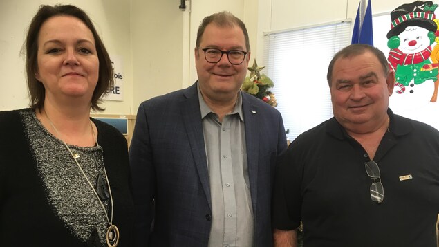 Les trois personnes posent en souriant