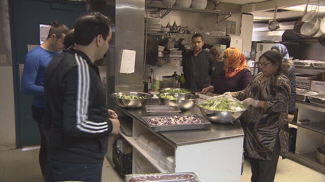 Une dizaine de personnes travaillant dans une cuisine Une dizaine de personnes travaillant dans une cuisine
