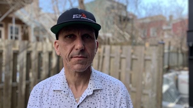 Un homme debout avec une casquette