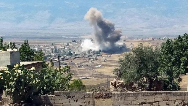 Une colonne de fumée s'élève à la suite d'une explosion dans un village syrien. Une colonne de fumée s'élève à la suite d'une explosion dans un village syrien.