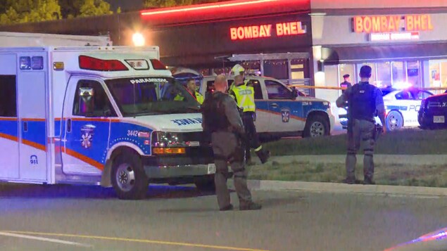 Photo de policiers et d'ambulanciers devant un restaurant. Photo de policiers et d'ambulanciers devant un restaurant.