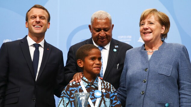 Le président français Emmanuel Macron, le premier ministre fidjien Frank Bainimarama, la chancelière allemande Angela Merkel et un enfant fidjien à la COP23, à Bonn en Allemagne. Le président français Emmanuel Macron, le premier ministre fidjien Frank Bainimarama, la chancelière allemande Angela Merkel et un enfant fidjien à la COP23, à Bonn en Allemagne.