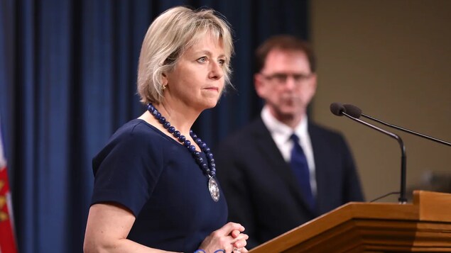 Bonnie Henry devant des micros lors d'une conférence de presse.