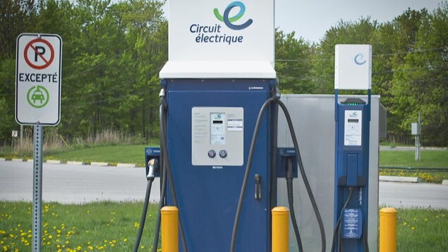 Une borne électrique protégée par des bollards.