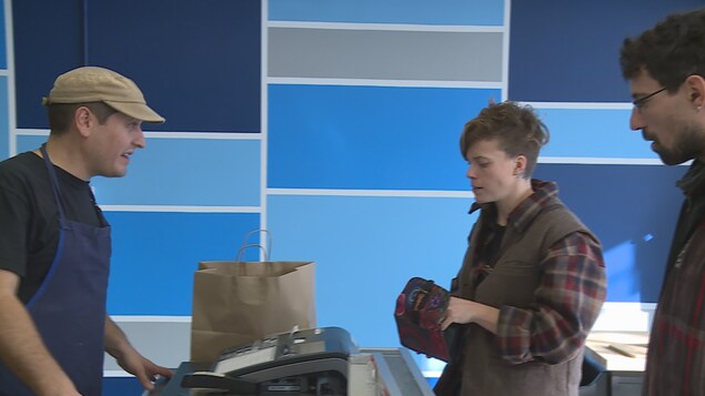 Un couple paie ses achats dans la boulangerie Un couple paie ses achats dans la boulangerie