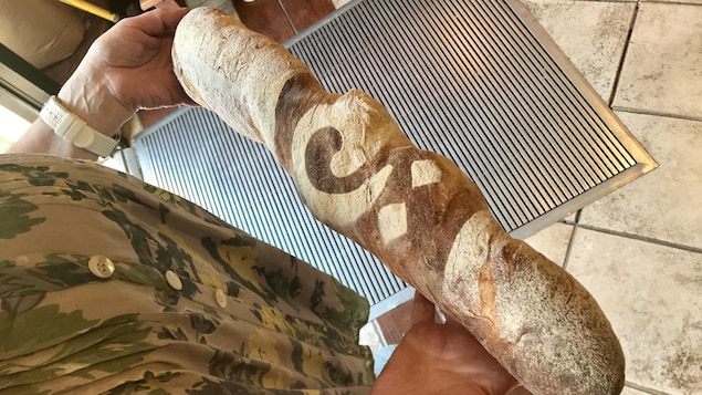 Mme Colletti montre la baguette à la caméra. Mme Colletti montre la baguette à la caméra.