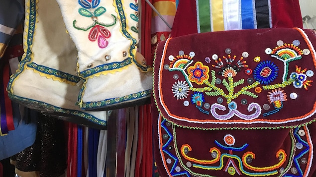 Un sac à main rouge-vin orné de perles accroché sur un présentoir. Un sac à main rouge-vin orné de perles accroché sur un présentoir.
