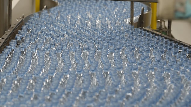 Plusieurs centaines de bouteilles de plastique vides défilent sur un tapis roulant dans une usine de Coca-Cola. Plusieurs centaines de bouteilles de plastique vides défilent sur un tapis roulant dans une usine de Coca-Cola.