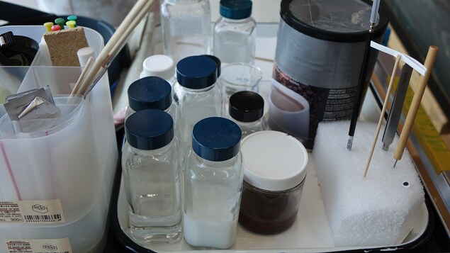 Des petites bouteilles de produis chimiques sont déposées sur un chariot.