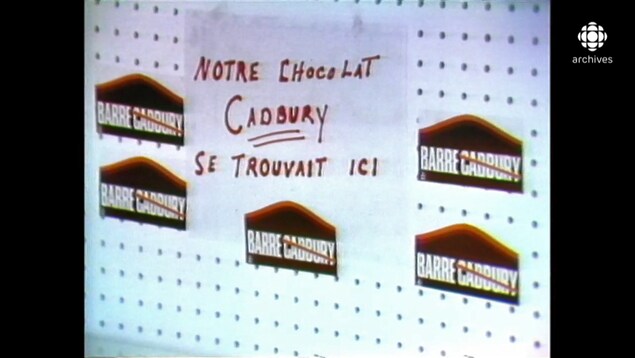 Étagère vide avec des autocollants de la campagne « On barre Cadvury » et une enseigne indiquant « Notre chocolat Cadbury se trouvait ici ».