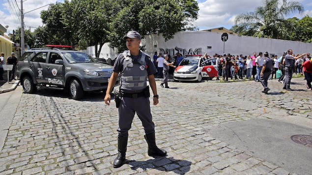 Des policiers montent la garde devant l'école publique Raul Brasil de Suzano, dans l'agglomération de Sao Paulo, au Brésil, où une fusillade a eu lieu le mercredi 13 mars 2019. 