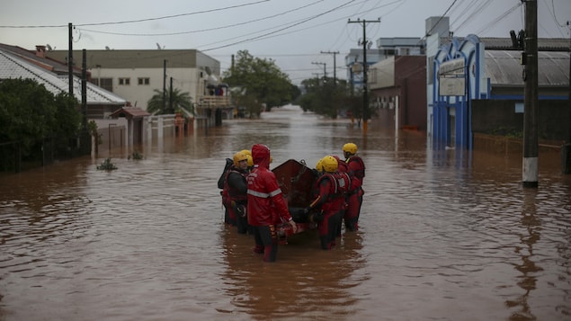 Une équipe de pompiers travaille dans une rue inondée.