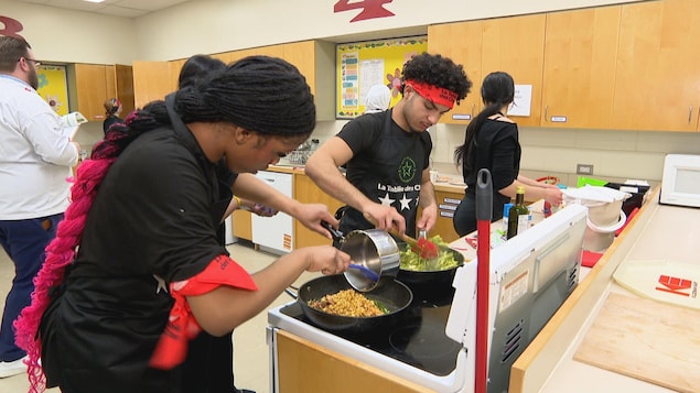 Des élèves du Collège West High, venant d'Halifax, s'activent à cuisiner un plat spécial durant la compétition «les brigades culinaires » de la Tablée des chefs. L'évènement se déroule à l'école Valley Gardens à Winnipeg.