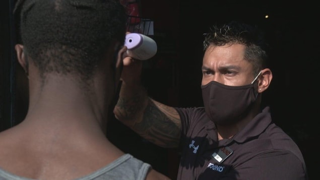 Un homme tient un thermomètre au laser