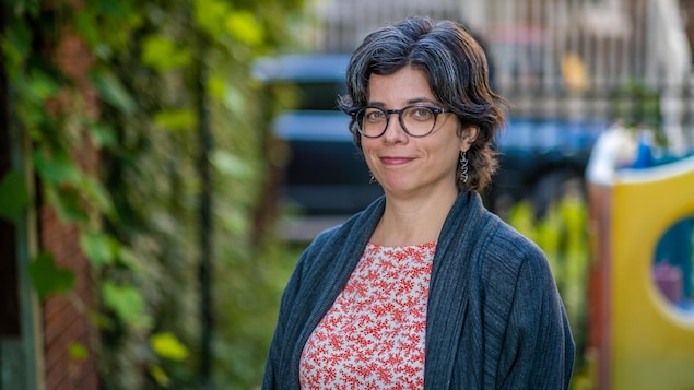 Claire Trottier pose pour la caméra dans une cour arrière en été.