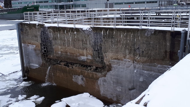 Le mur de l'écluse est endommagé et de l'eau coule.