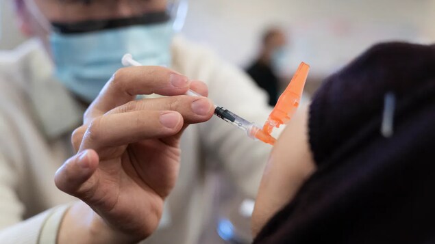 Isang health-care worker ang nagsasaksak ng injection.