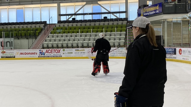 Une entraîneuse adjointe derrière le banc des Rapides