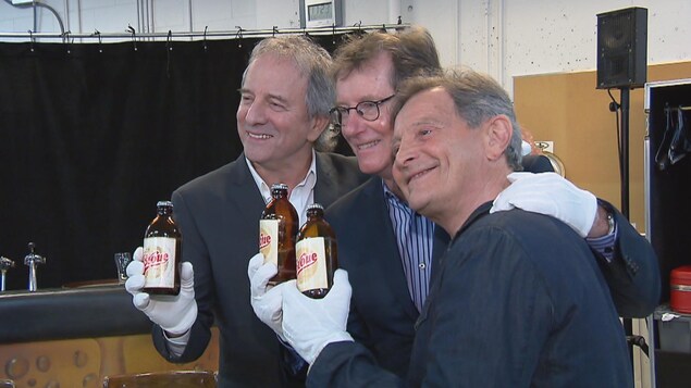 Les comédiens Michel Côté, Marc Messier et Marcel Gauthier qui tiennent une bouteille étiquetée Broue Les comédiens Michel Côté, Marc Messier et Marcel Gauthier qui tiennent une bouteille étiquetée Broue