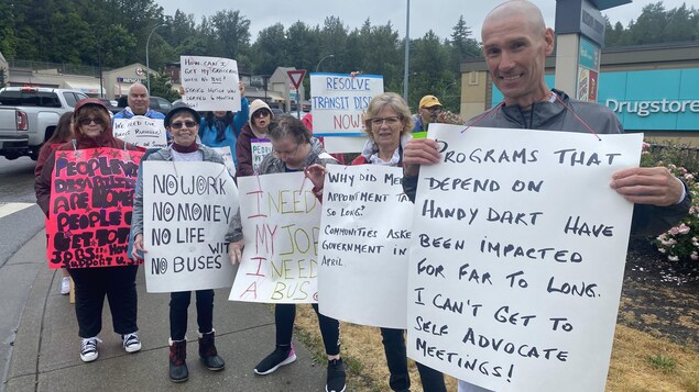 Bryce Schaufelberger et des manifestants qui tiennent des pancartes. 