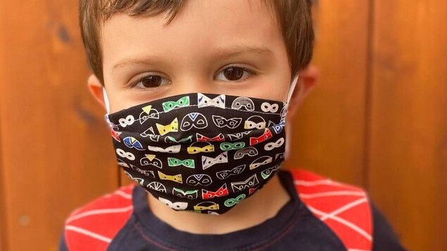 Un garçon porte un masque de protection.