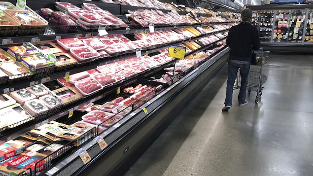 FILE - In this May 10, 2020 file photo, a shopper pushes his cart past a display of packaged meat in a grocery store in southeast Denver.  U.S. wholesale prices jumped 0.4% in September as food costs rose by the largest amount since May. The Labor Department said Wednesday, Oct. 14,  that the September increase in its producer price index, which measures inflation before it reaches the consumer, followed a 0.3% rise in August and a 0.6% surge in July which had been the biggest monthly gain sinc